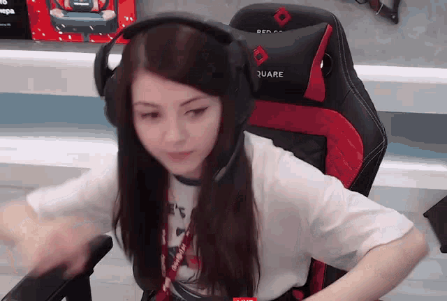 a woman wearing headphones sits in a red and black chair