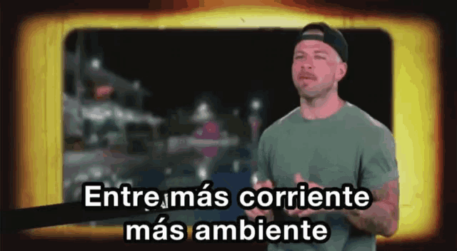 a man stands in front of a screen with the words entre mas corriente mas ambiente on it