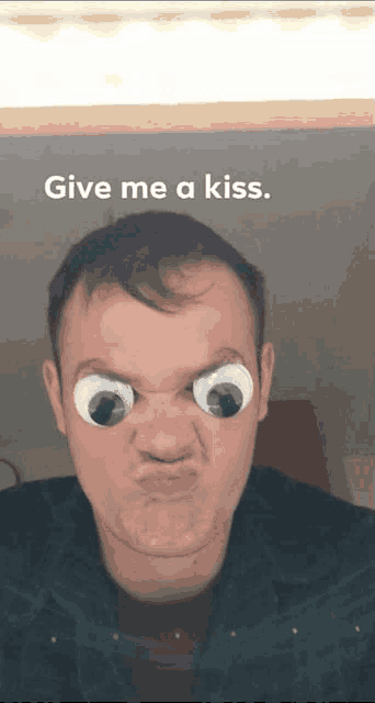 a man is making a funny face with googly eyes and the words give me a kiss