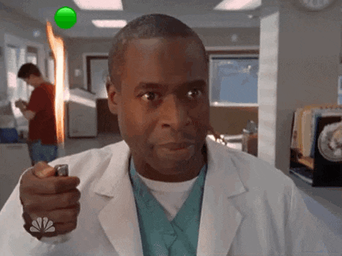 a man in a lab coat is holding a lighter in his hand in a hospital .