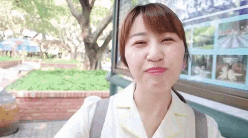 a woman making a face in front of a sign that says ' disneyland '
