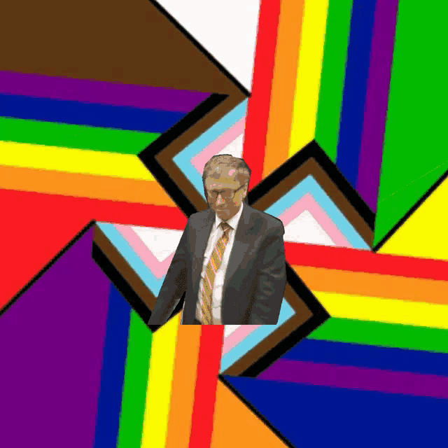a man in a suit and tie is standing in front of a rainbow flag