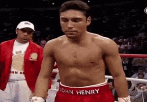 a shirtless boxer wearing red shorts with the name john henry on them