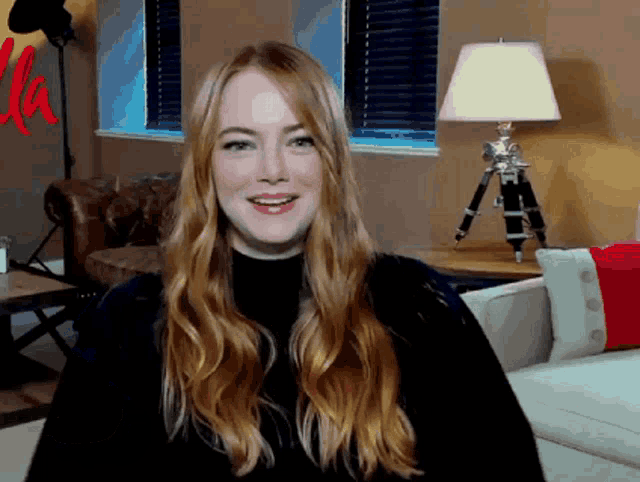 a woman in a living room with a lamp and a sign that says la