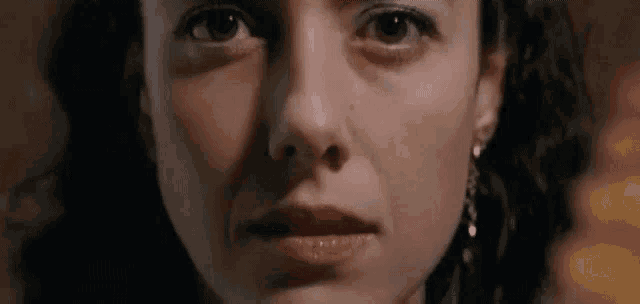 a close up of a woman 's face with a tear running down her cheek .