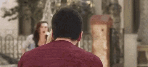 a man in a red shirt is looking at a woman in a blue dress .
