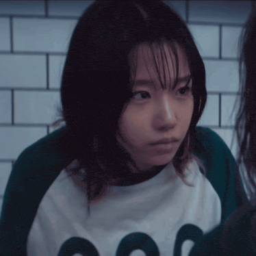 a girl wearing a white shirt with a green circle on it