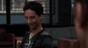 a man is sitting in a chair in a room with a woman .