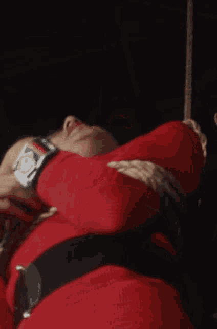 a woman in a red sweater is tied up with ropes