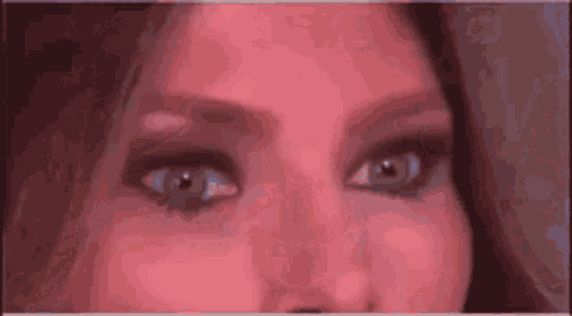 a close up of a woman 's eyes with a red background