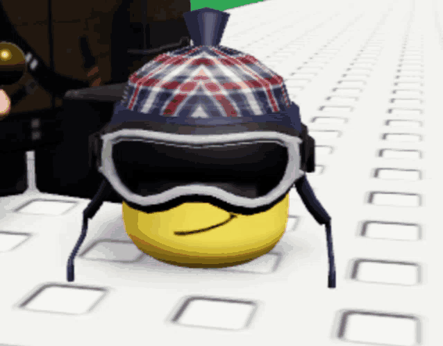 a smiley face wearing a hat and goggles