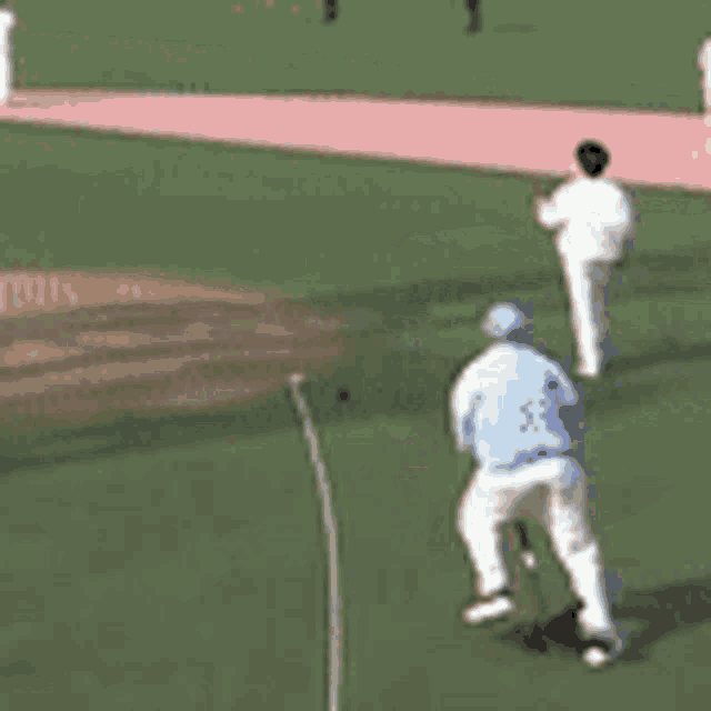 a man in a blue shirt is standing on a baseball field holding a bat