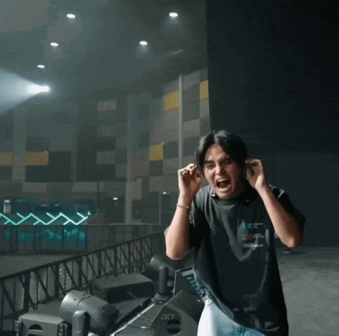 a man covering his ears in front of a speaker that says zkv on it