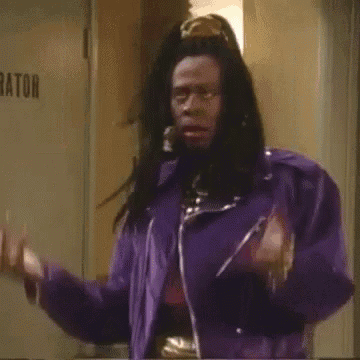 a man with dreadlocks is wearing a purple jacket and a crown on his head .