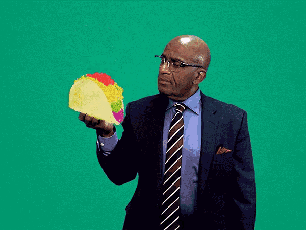 a man in a suit is throwing a taco in the air