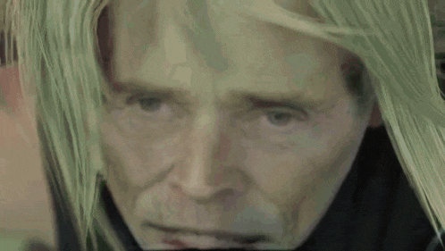 a close up of a man with long green hair