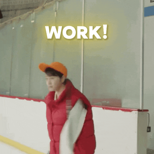 a man wearing a red jacket and an orange hat is standing on an ice rink with the word work behind him