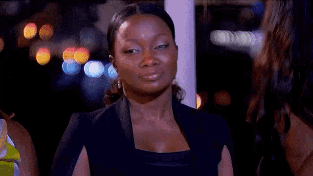a woman in a black dress is sitting in front of a window and says `` oh lawd '' .