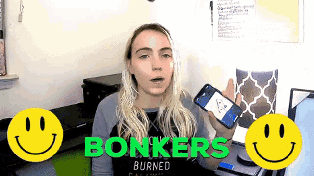 a woman is holding a cell phone in front of two smiley faces that say bonkers burned
