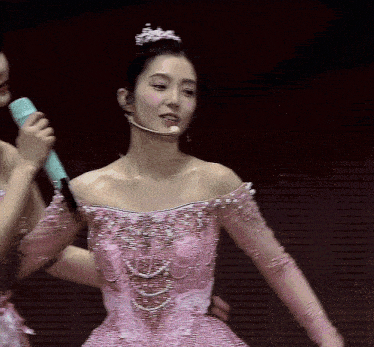 a woman in a pink dress has a tiara on her head