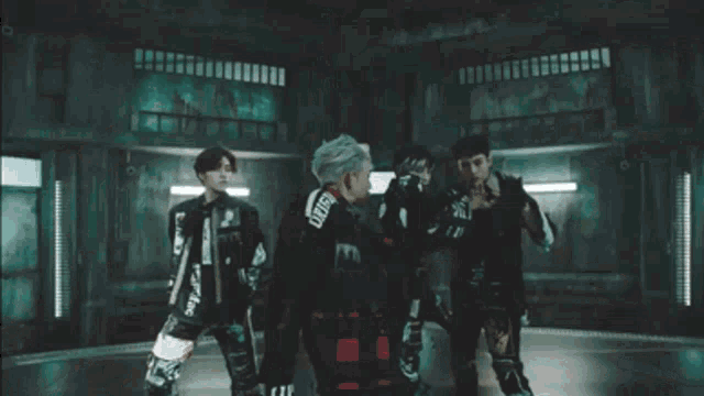 a group of young men are standing in a room .