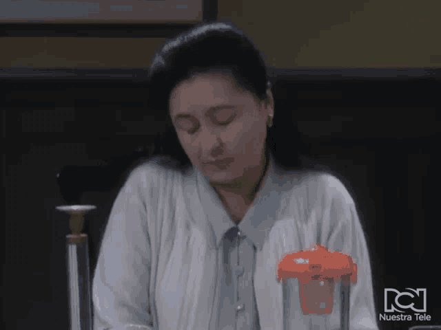 a woman sitting in front of a blender with nuestra tele on the bottom right