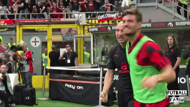 two soccer players shake hands in front of a banner that says sempre