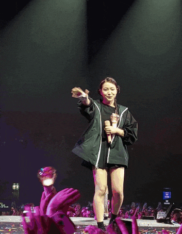 a woman singing into a microphone on stage