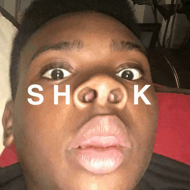 a close up of a person 's face with the word shook written above it