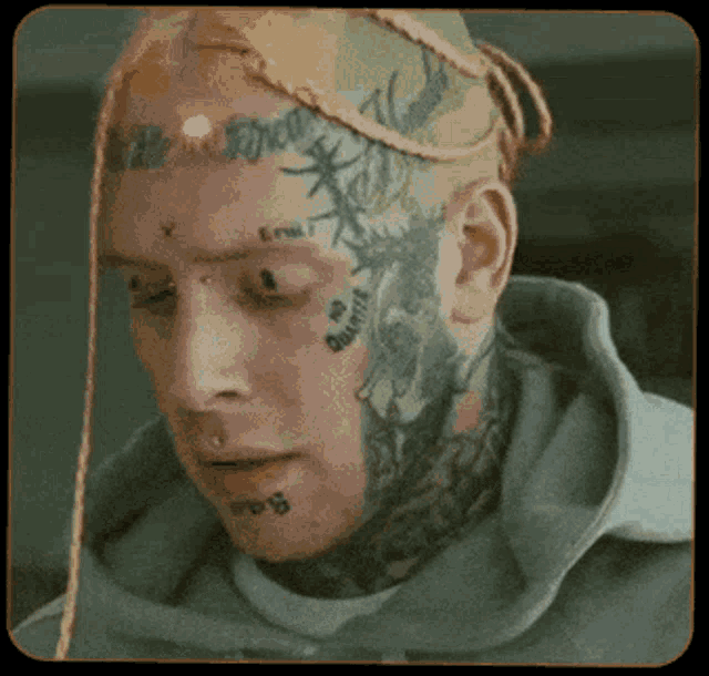 a man with a lot of tattoos on his face including one that says " x "