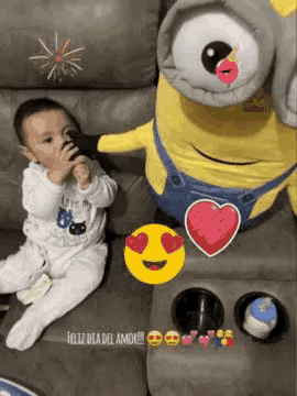 a baby is sitting on a couch next to a large stuffed minion .