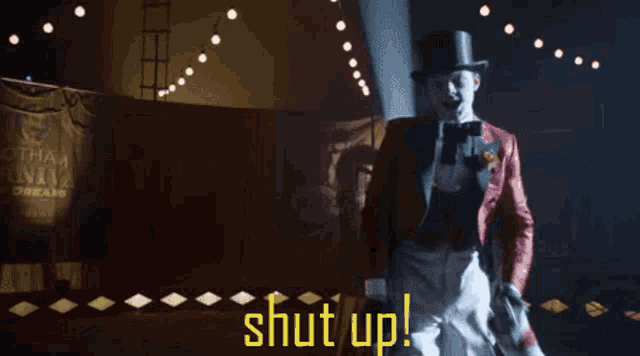 a man in a top hat is standing in front of a sign that says " shut up "