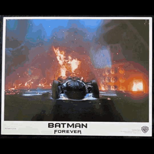 a poster for the movie batman forever shows a car on fire