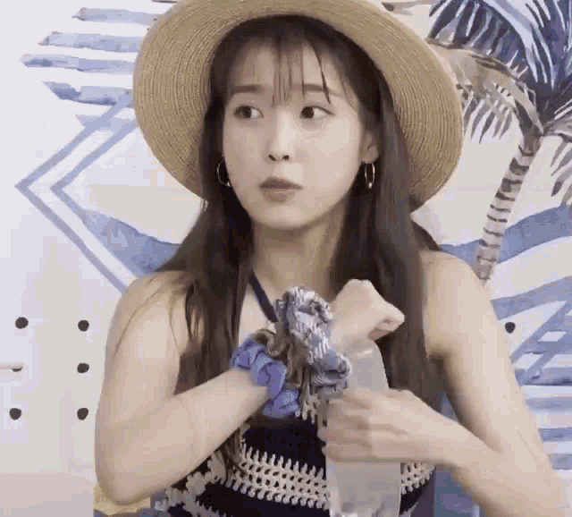 a woman wearing a straw hat and a scrunchie around her wrist .