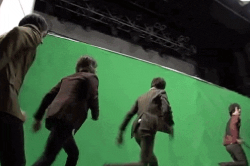a group of men are dancing in front of a green screen