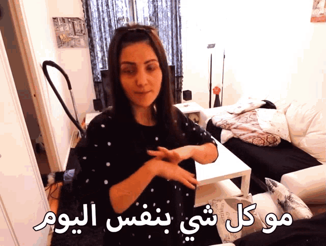 a woman stands in a living room with arabic writing on the walls