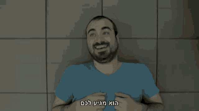 a man in a blue shirt is smiling with a foreign language behind him