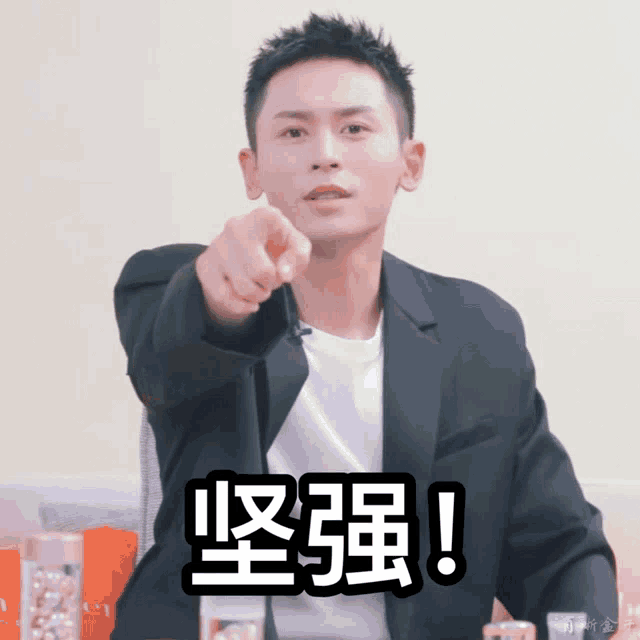 a man in a suit pointing at the camera with chinese writing on the bottom right