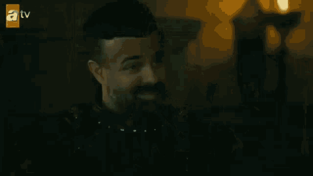a man with a beard is holding a large knife in his hand .