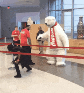 a coca cola polar bear mascot is standing in a lobby