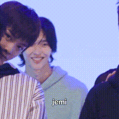 a group of people are standing next to each other and one of them is wearing a striped shirt .