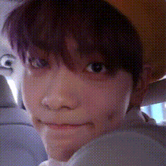 a close up of a person 's face with purple hair and a hat on .