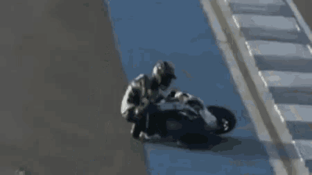 a man is riding a motorcycle on a blue road .