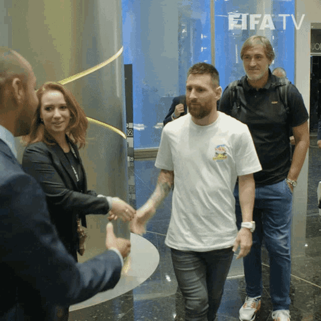 a man in a white shirt is shaking hands with a woman