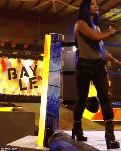 a woman with blue hair is standing in front of a sign that says bay lf
