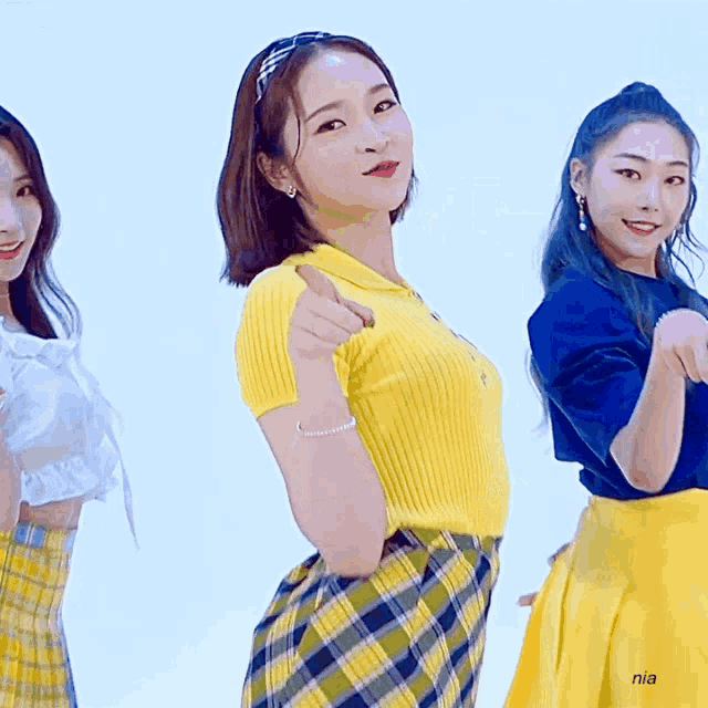 a girl wearing a yellow shirt and a plaid skirt has nia written on the bottom of her skirt