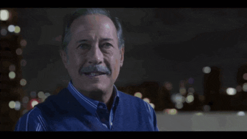 a man with a mustache wearing a blue shirt
