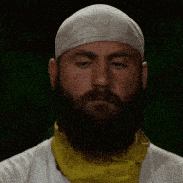 a man with a beard wearing a bandana and a yellow scarf around his neck