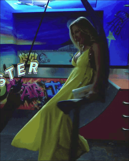 a woman in a yellow dress is standing in front of an aquarium with the name ramonac on the bottom right
