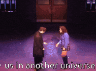 two people standing on a stage with the words " us in another universe "